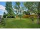 Spacious backyard with lush green grass, mature trees, and a wooden fence, creating a private outdoor space at 1481 Wrenwood Dr, Columbus, IN 47201