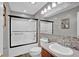 Bathroom featuring modern tiles, updated fixtures, a shower with glass doors, and vanity with sink at 1481 Wrenwood Dr, Columbus, IN 47201
