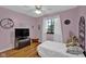Bedroom features wood flooring, white ceiling fan, large window, and a trunk at the foot of the bed at 1481 Wrenwood Dr, Columbus, IN 47201
