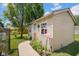 Exterior view of shed featuring siding, a window box with flowers, a flamingo statue, and a walkway at 1481 Wrenwood Dr, Columbus, IN 47201