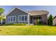 The backyard boasts a well-manicured lawn, grey siding, black framed windows and a brick covered patio at 15600 Woodford Dr, Westfield, IN 46074