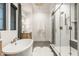 Bright bathroom featuring a soaking tub, glass shower with bench, and a stylish vanity with modern fixtures at 15600 Woodford Dr, Westfield, IN 46074