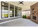 Covered patio with brick fireplace and black-trimmed windows overlooking pond at 15600 Woodford Dr, Westfield, IN 46074