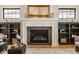 Living room fireplace with dark marble hearth and white mantel flanked by decorative shelving and bright windows at 15600 Woodford Dr, Westfield, IN 46074