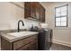 Laundry room features a sink, countertop, dark wood cabinets, and modern washer at 15600 Woodford Dr, Westfield, IN 46074