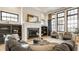 Bright living room with fireplace, black framed windows, hardwood floors, and comfortable seating arrangement at 15600 Woodford Dr, Westfield, IN 46074