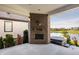 Covered patio with brick fireplace, outdoor hot tub and a view of the community pond at 15600 Woodford Dr, Westfield, IN 46074