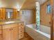 Cozy bathroom featuring wood cabinets, tile walls, and a shower-tub combo at 1602 California St, Columbus, IN 47201