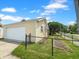 View of the detached one-car garage, exterior, fenced yard, and driveway at 1602 California St, Columbus, IN 47201