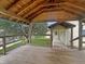 Wooden covered porch with seating space and views of the backyard and house at 1602 California St, Columbus, IN 47201