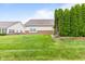 Side yard features a lawn and mature landscaping at 1605 Leisure Way, Greenfield, IN 46140
