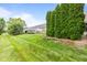 Backyard featuring mature landscaping and green grass at 1605 Leisure Way, Greenfield, IN 46140