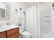 Bright bathroom with a wood vanity, white sink, toilet, and a shower/tub combination with a shower curtain at 1605 Leisure Way, Greenfield, IN 46140