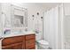 Well-lit bathroom with a wood vanity, white sink, toilet, and a shower/tub combination with a patterned curtain at 1605 Leisure Way, Greenfield, IN 46140