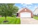 Beautiful brick home featuring a well-kept lawn, mature trees, and an attached garage at 1605 Leisure Way, Greenfield, IN 46140