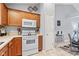 Kitchen features white appliances, wood cabinets, and open access to the dining area at 1605 Leisure Way, Greenfield, IN 46140