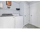 Well-lit laundry room featuring a washer and dryer set with overhead shelving for ample storage space at 1605 Leisure Way, Greenfield, IN 46140