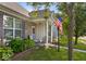 Inviting front porch with seating, well-maintained lawn and an American flag at 2017 Shadow Creek Blvd, Columbus, IN 47201