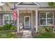 Inviting brick home features rocking chairs and a covered front porch with tidy landscaping at 2017 Shadow Creek Blvd, Columbus, IN 47201