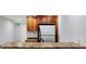 Basement wet bar area with wood cabinets, granite countertops, and stainless steel fridge at 2263 Glebe St, Carmel, IN 46032