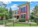 Charming two-story home with a manicured lawn, mature trees and black iron fence at 2263 Glebe St, Carmel, IN 46032