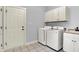 Functional laundry room equipped with modern washer, dryer, and built-in storage cabinets at 2263 Glebe St, Carmel, IN 46032