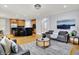 Open-concept living room features hardwood floors, a view into the kitchen, modern decor, and comfortable seating at 2263 Glebe St, Carmel, IN 46032