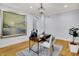 Contemporary office space featuring hardwood floors, a large painting, a modern desk, and plenty of natural light at 2263 Glebe St, Carmel, IN 46032