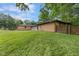 Large backyard of a brick home, showcasing a well-maintained lawn, mature trees, and a wooden fence at 2750 Chamberlin Dr, Indianapolis, IN 46227