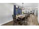 Dining area with views into the kitchen, a large table, wood floors, and modern lighting at 2750 Chamberlin Dr, Indianapolis, IN 46227