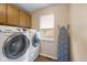 Well-equipped laundry room with a front-loading Samsung washer and dryer, and wooden cabinets above at 2750 Chamberlin Dr, Indianapolis, IN 46227