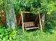 A charming wooden swing sheltered by lush trees offers a peaceful backyard retreat at 2922 E 62Nd St, Indianapolis, IN 46220