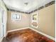A bedroom featuring wood floors, a window, and a doorway, awaiting renovation at 3042 Newton Ave, Indianapolis, IN 46201