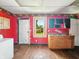 A small kitchen featuring red walls, a sink, and a window, awaiting renovation at 3042 Newton Ave, Indianapolis, IN 46201