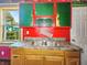 A small kitchen featuring red walls, granite countertops, and cabinets awaiting renovation at 3042 Newton Ave, Indianapolis, IN 46201