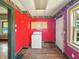A small kitchen featuring red walls, a washing machine and cabinets, awaiting renovation at 3042 Newton Ave, Indianapolis, IN 46201