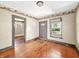 A living room featuring wood floors, a window, and a front door, awaiting renovation at 3042 Newton Ave, Indianapolis, IN 46201