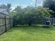 Grassy backyard with mature trees, playground equipment, and privacy fence at 3143 Carson Ave, Indianapolis, IN 46227