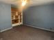 Bedroom with outdated blue walls and carpet, showcasing a built-in shelving unit at 3143 Carson Ave, Indianapolis, IN 46227