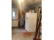This garage features a white refrigerator, unfinished walls, and access to the outside at 3143 Carson Ave, Indianapolis, IN 46227