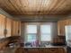 Corner kitchen with wood paneled ceiling, oak cabinets, laminate countertops and stainless refrigerator at 3143 Carson Ave, Indianapolis, IN 46227