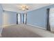 Spacious bedroom with blue walls, plush carpeting, ceiling fan, and plenty of natural light at 3230 Hemlock St, Whiteland, IN 46184