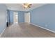 Bright bedroom with blue walls, plush carpeting, ceiling fan, and open doorway at 3230 Hemlock St, Whiteland, IN 46184