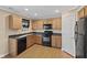 Efficient kitchen layout with wooden cabinets, black appliances, and linoleum floors at 3230 Hemlock St, Whiteland, IN 46184