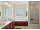 Well-lit bathroom with double sinks, a large soaking tub, and a separate glass-enclosed shower at 35 Decourcy Ln, Franklin, IN 46131