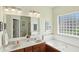 Bright bathroom featuring double sinks, a large soaking tub, and a privacy glass window for natural light at 35 Decourcy Ln, Franklin, IN 46131