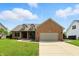 Inviting single-story brick home with a well-maintained lawn and attached garage at 35 Decourcy Ln, Franklin, IN 46131