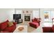 Cozy living room with a fireplace, plush red furniture, and natural light at 35 Decourcy Ln, Franklin, IN 46131