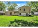 Large backyard featuring lush green grass, shade trees, and exterior access to the basement at 3663 Kline N Dr, Indianapolis, IN 46226