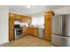 Kitchen featuring wood cabinetry, stainless steel appliances, and subway tile backsplash at 3663 Kline N Dr, Indianapolis, IN 46226